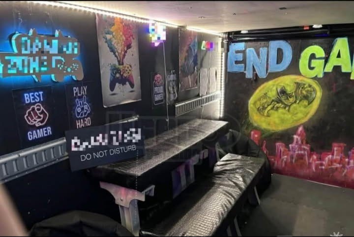Seating area inside the trailer with padded benches and a graffiti END GAME mural